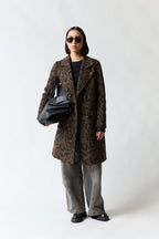 mujer vistiendo chaqueta café Umbrale, estilo urbano en estudio