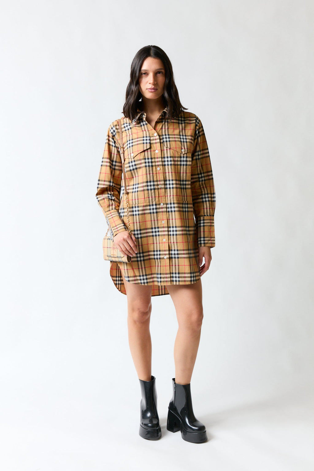 mujer vistiendo camisa café Burberry, estilo urbano en estudio