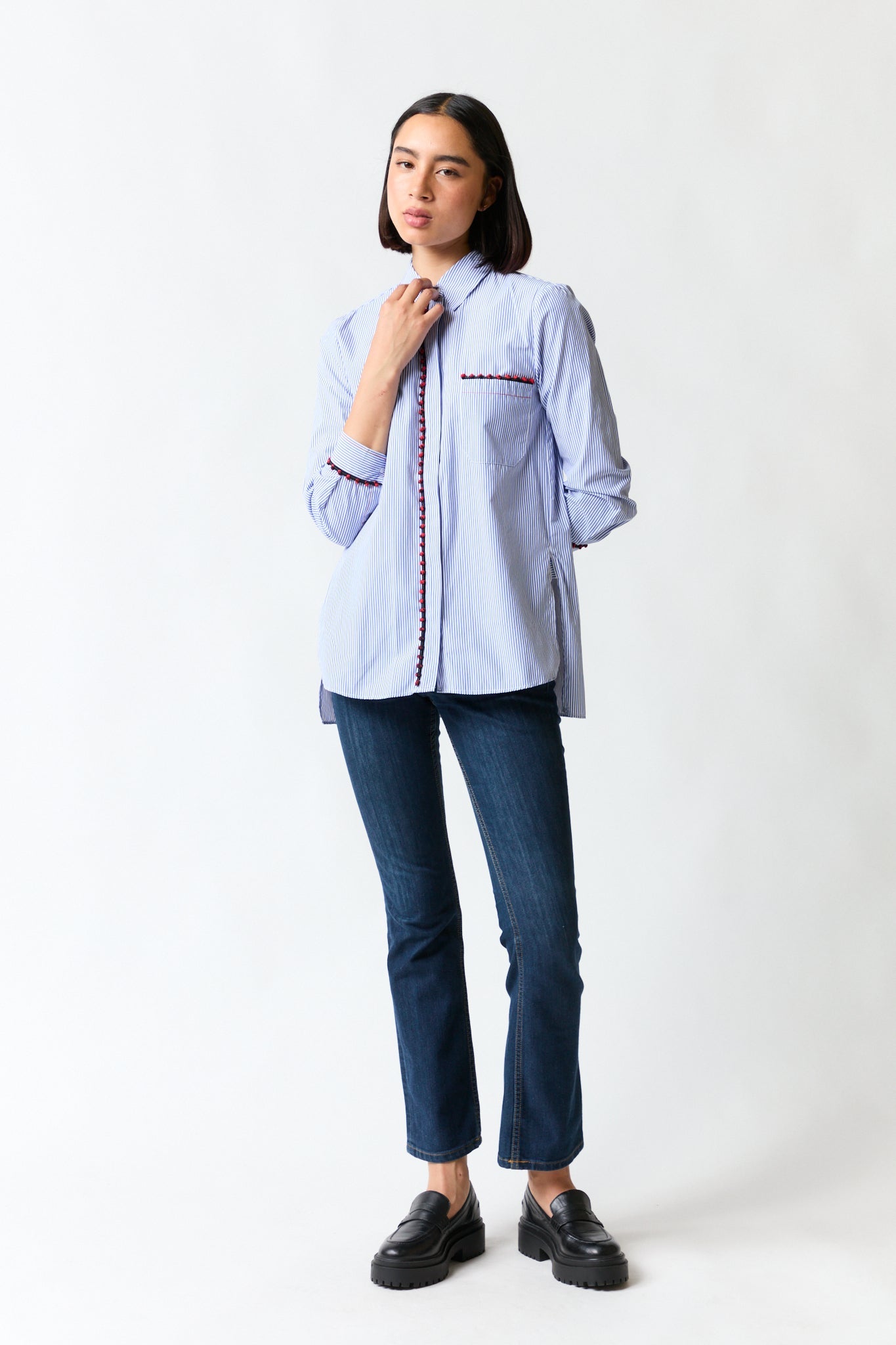 mujer vistiendo camisa blanco azul rojo Zara, estilo urbano en estudio