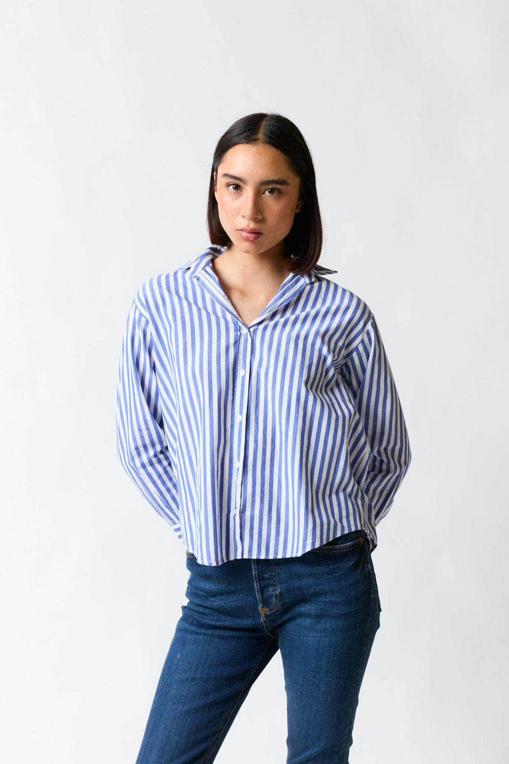 mujer vistiendo camisa blanco azul Zara, estilo urbano en estudio