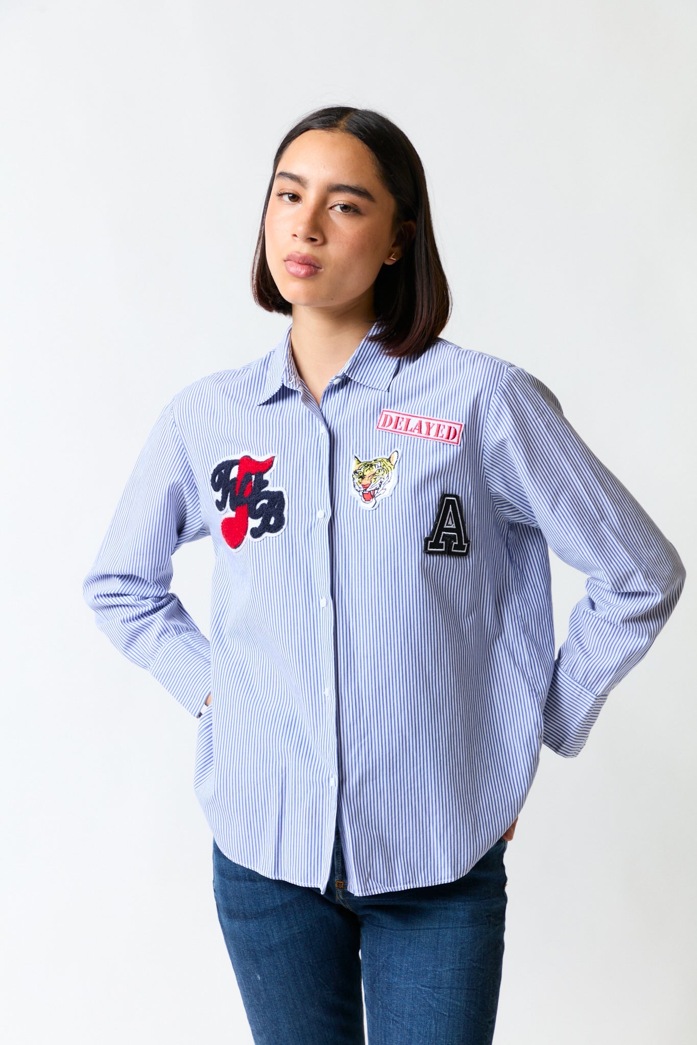 mujer vistiendo camisa blanco azul Zara, estilo urbano en estudio