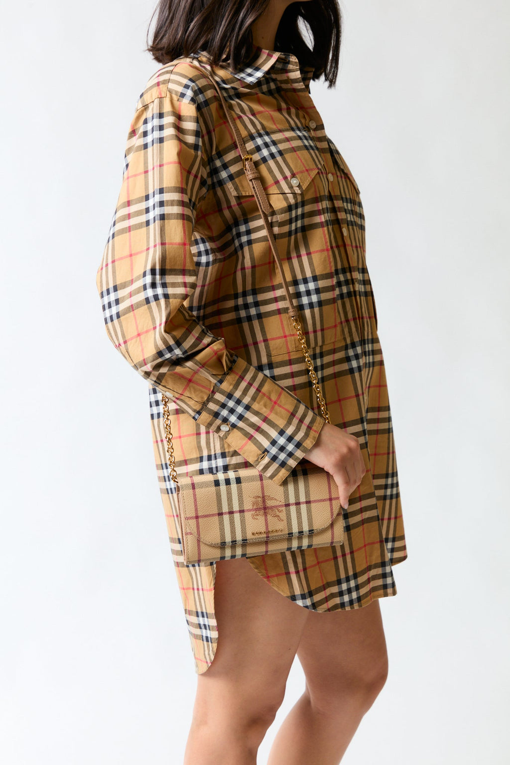 mujer vistiendo producto beige Burberry, estilo urbano en estudio