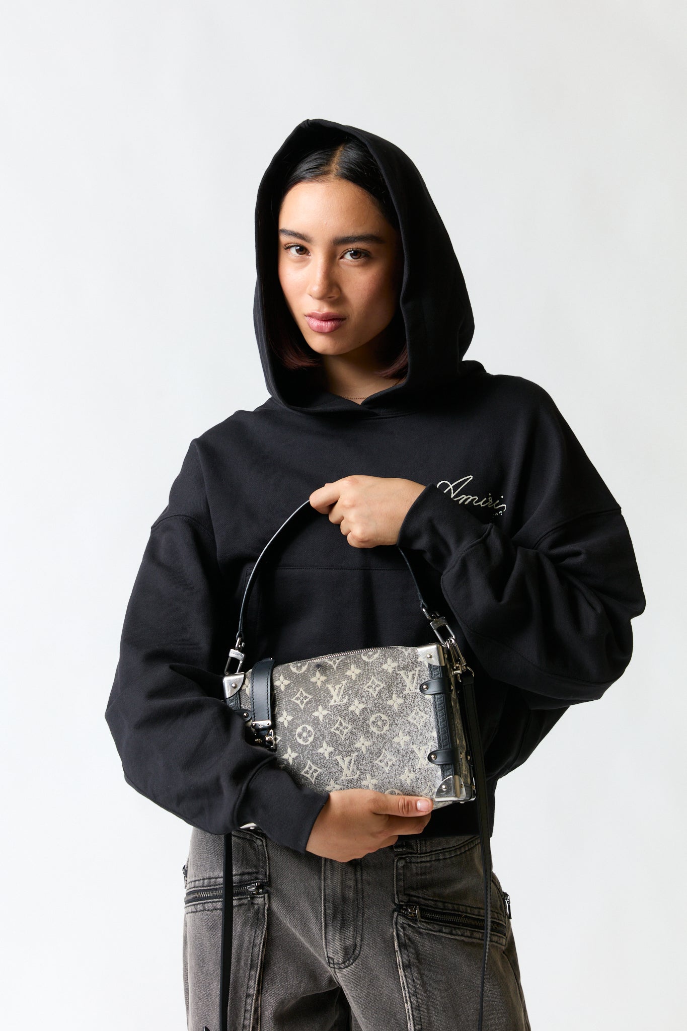 mujer vistiendo producto gris LV, estilo urbano en estudio