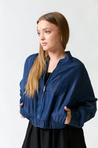 mujer vistiendo chaqueta azul Calvin Klein, estilo urbano en estudio