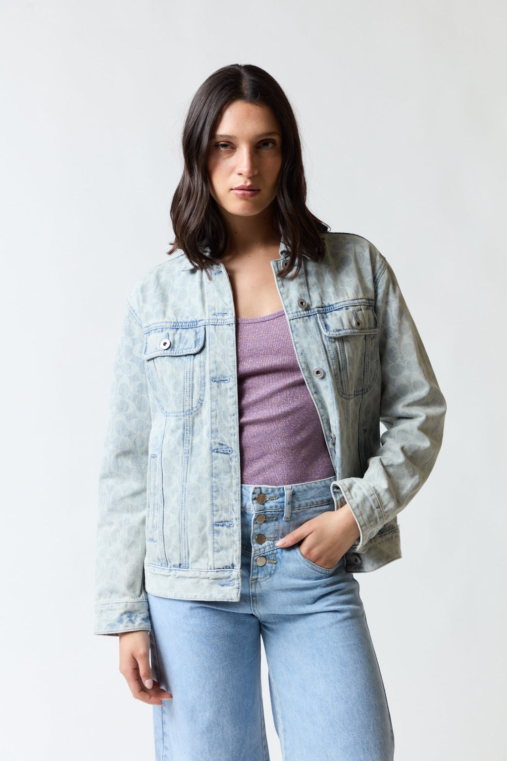 mujer vistiendo chaqueta denim azul Coach, estilo urbano en estudio