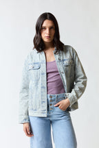 mujer vistiendo chaqueta denim azul Coach, estilo urbano en estudio