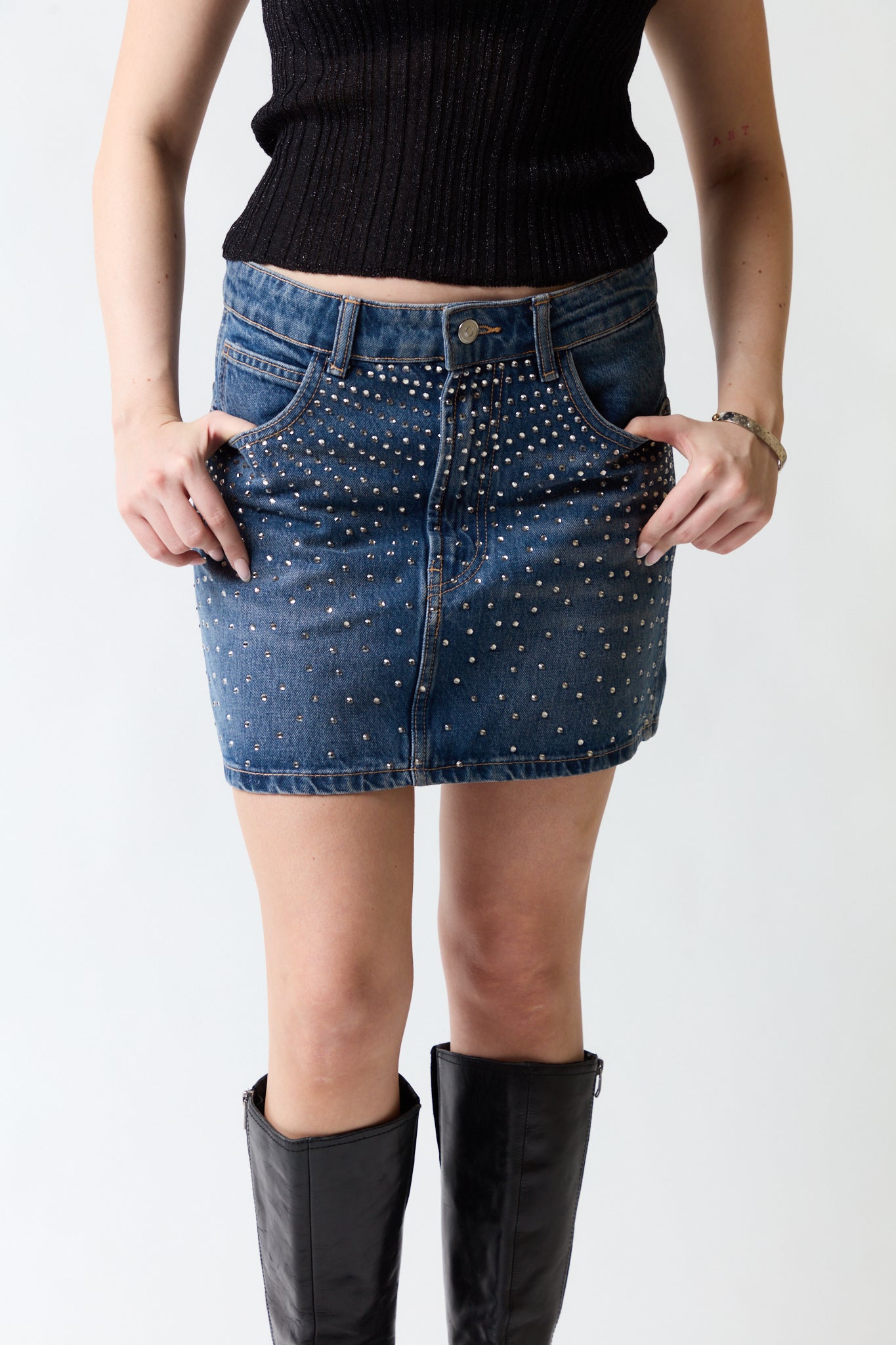 mujer vistiendo falda denim azul Zara, estilo urbano en estudio