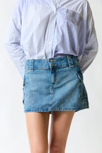 mujer vistiendo falda denim azul H&M, estilo urbano en estudio