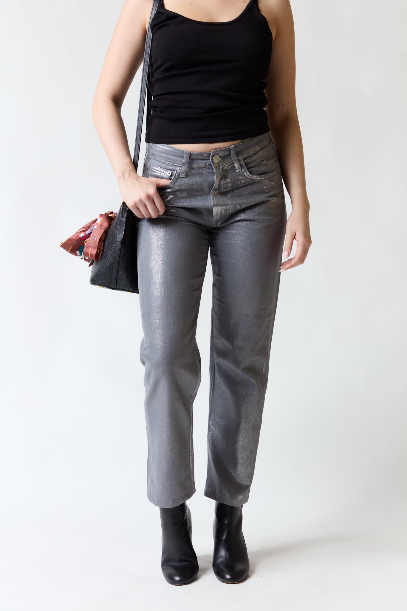 mujer vistiendo pantalón brillante gris Zara, estilo urbano en estudio
