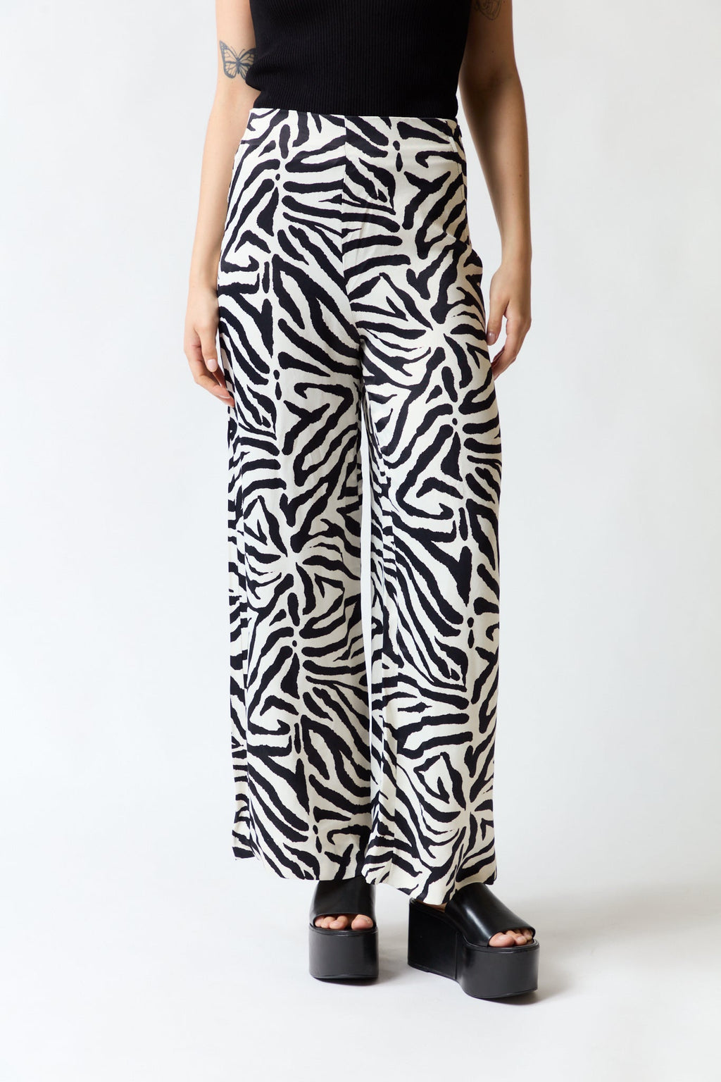 mujer vistiendo pantalón cebra negro blanco Zara, estilo urbano en estudio