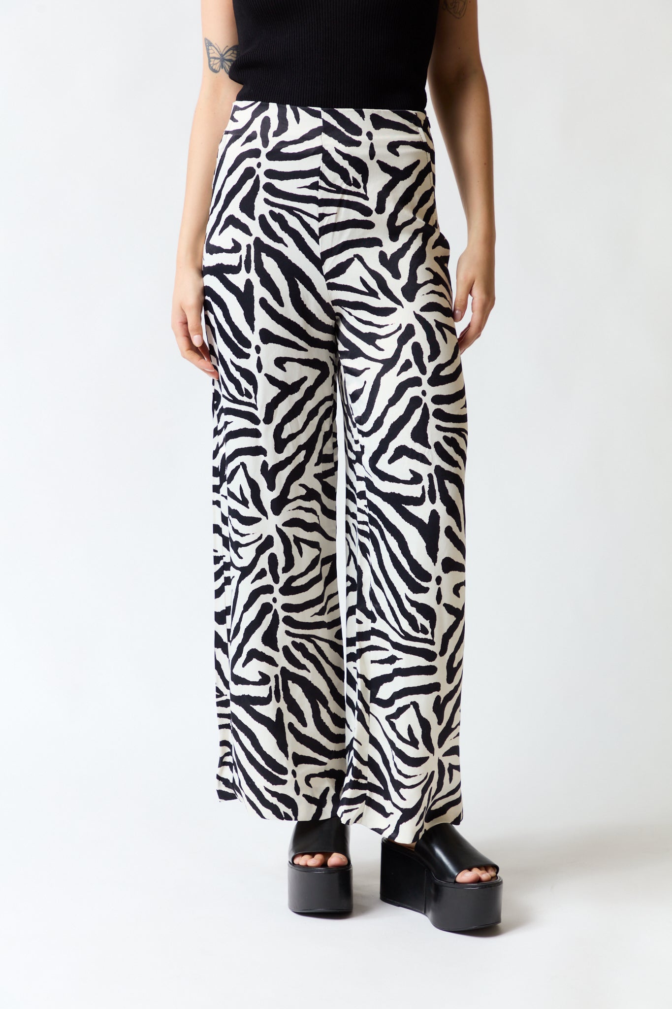 mujer vistiendo pantalón cebra negro blanco Zara, estilo urbano en estudio