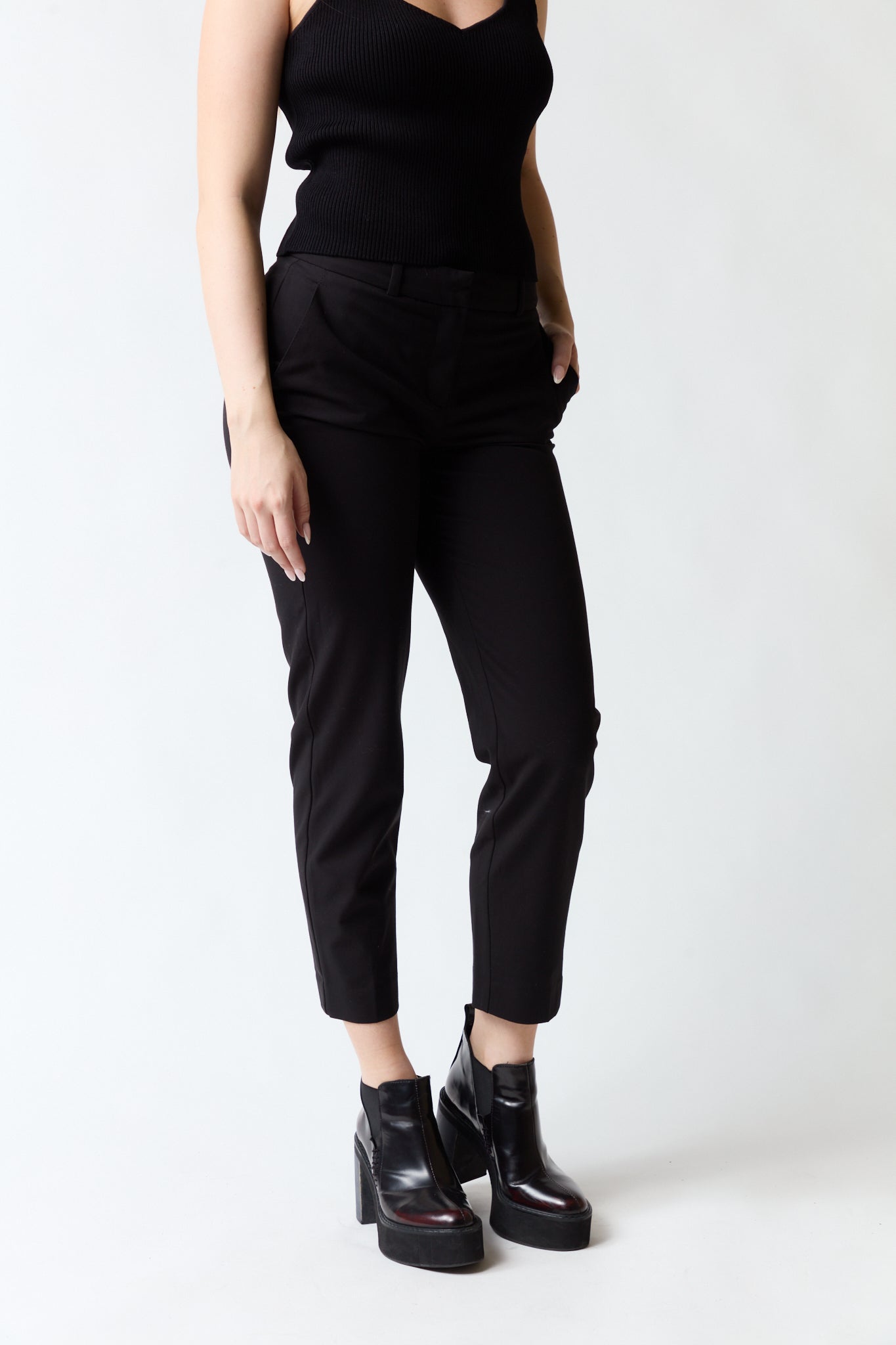 mujer vistiendo pantalón negro Mango, estilo urbano en estudio