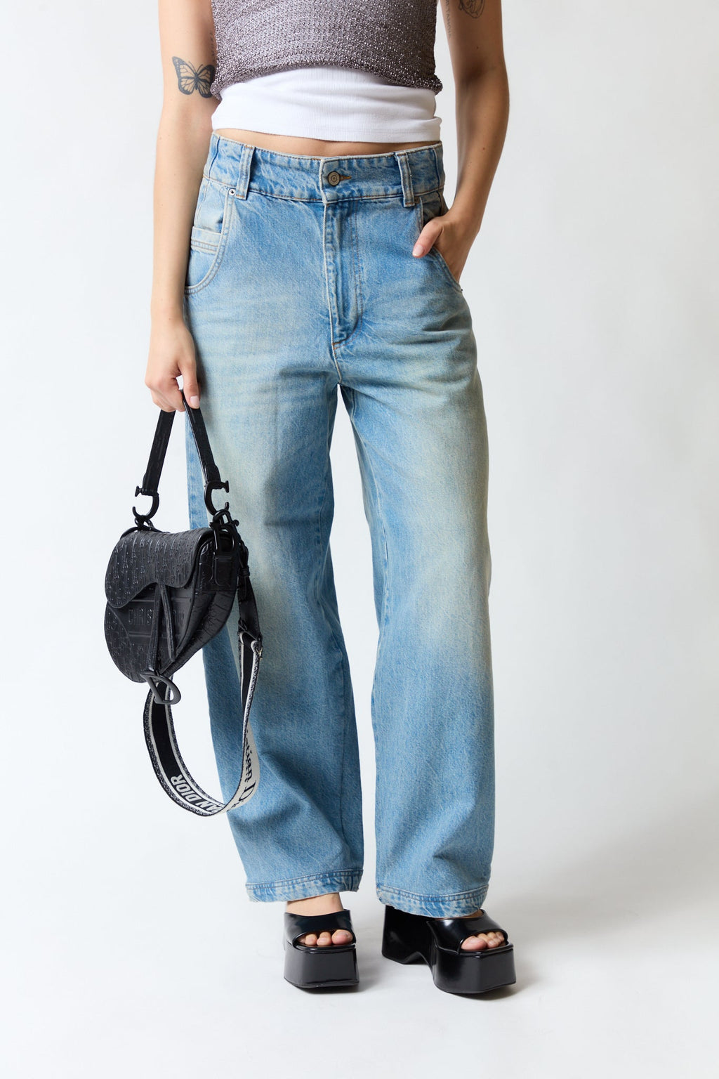 mujer vistiendo pantalón denim azul Zara, estilo urbano en estudio