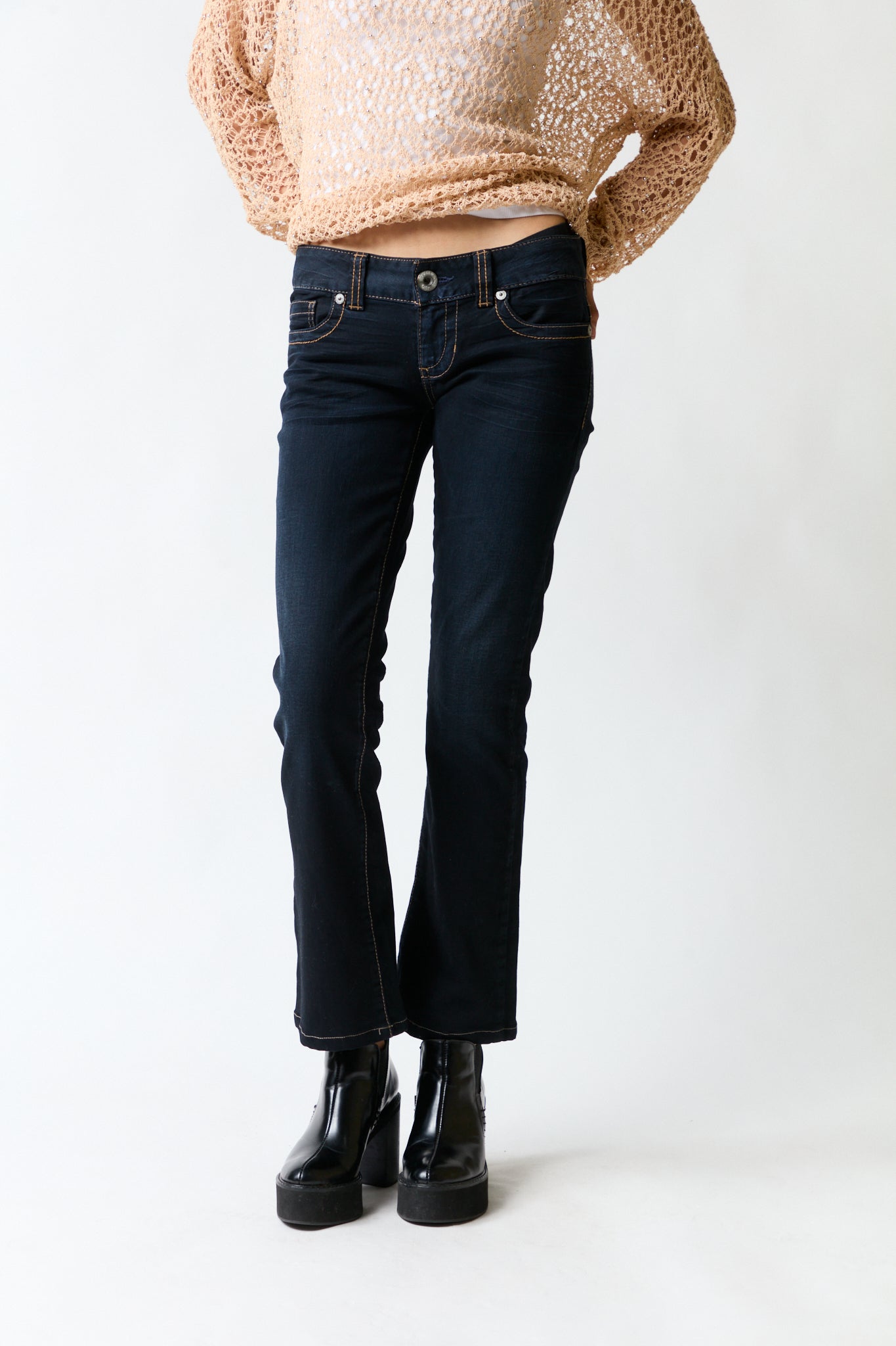mujer vistiendo pantalón denim azul Guess, estilo urbano en estudio