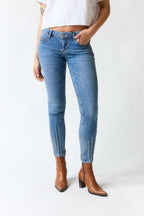 mujer vistiendo pantalón denim azul Guess, estilo urbano en estudio