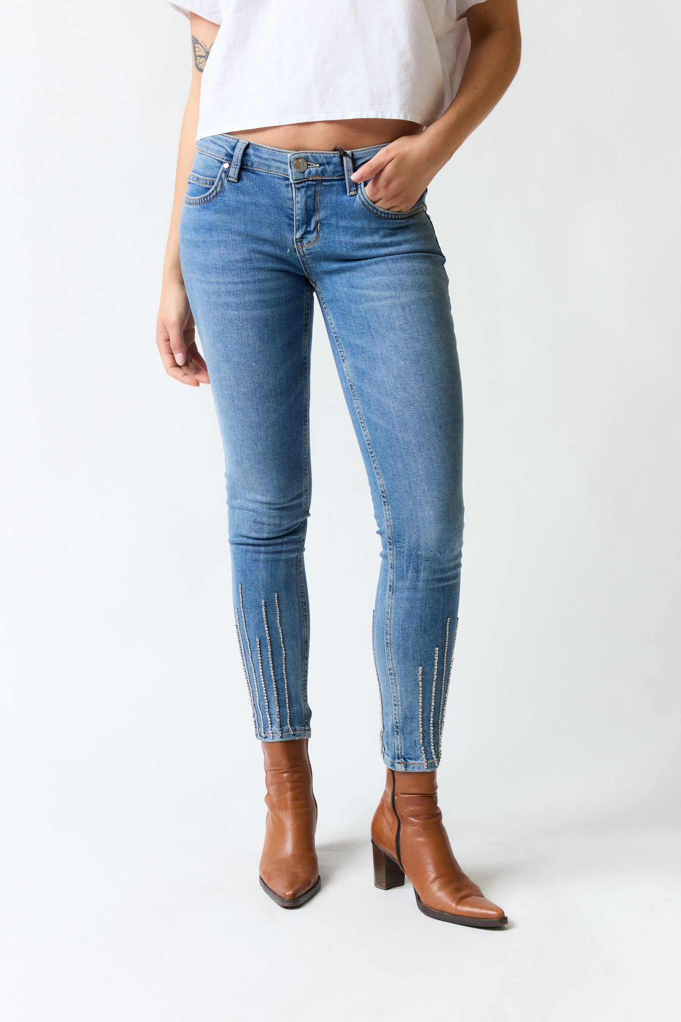 mujer vistiendo pantalón denim azul Guess, estilo urbano en estudio