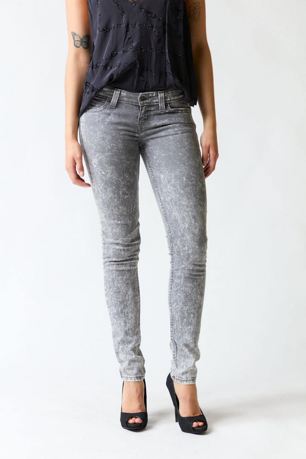 mujer vistiendo pantalón denim gris Levis, estilo urbano en estudio