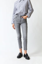 mujer vistiendo pantalón denim gris Guess, estilo urbano en estudio