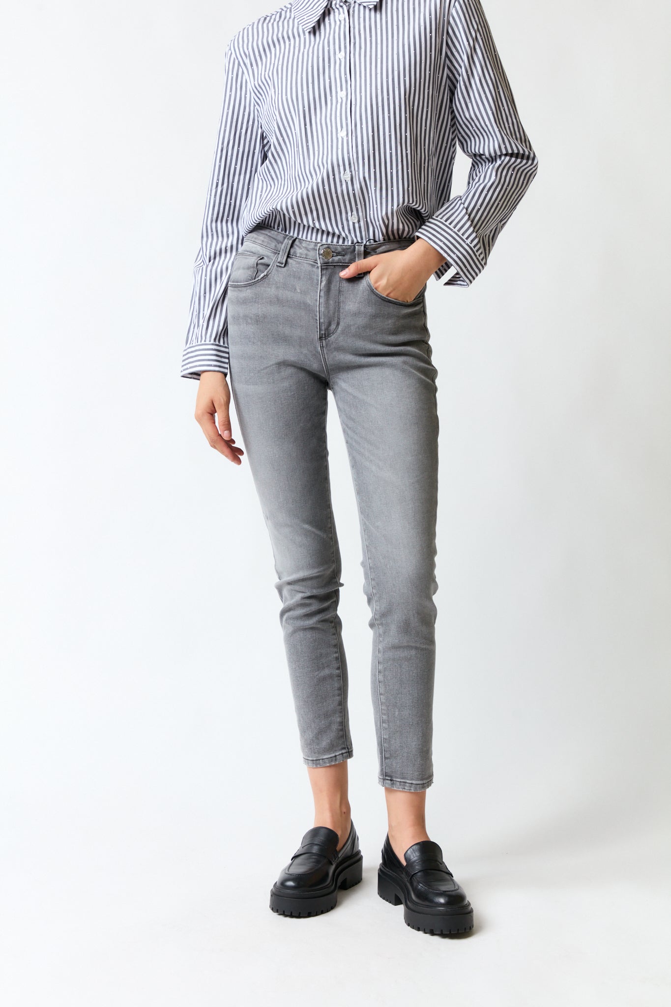 mujer vistiendo pantalón denim gris Guess, estilo urbano en estudio