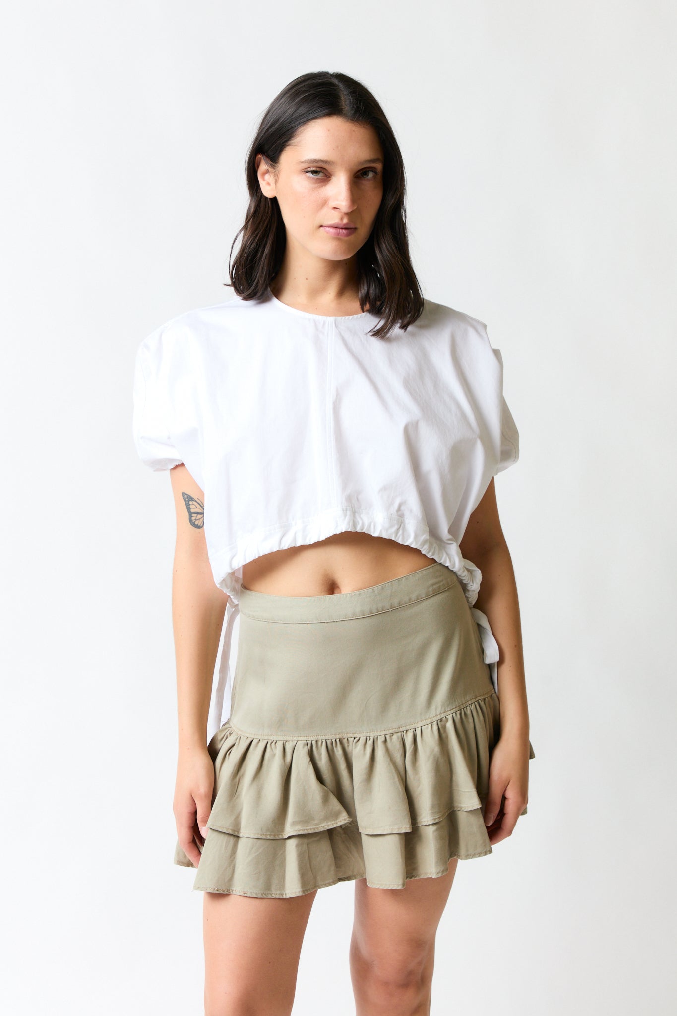 mujer vistiendo polera blanco Zara, estilo urbano en estudio