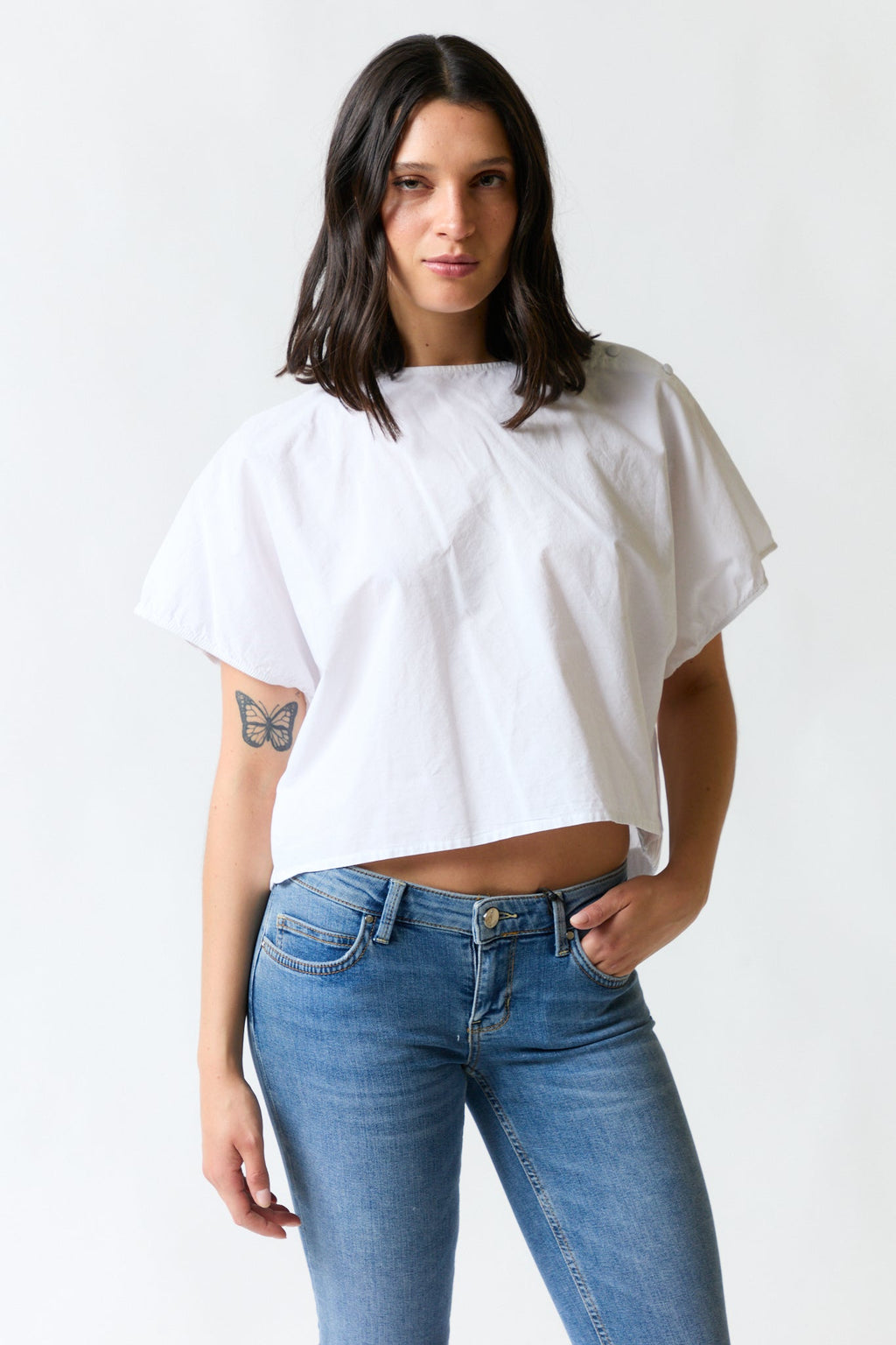 mujer vistiendo polera blanco Zara, estilo urbano en estudio