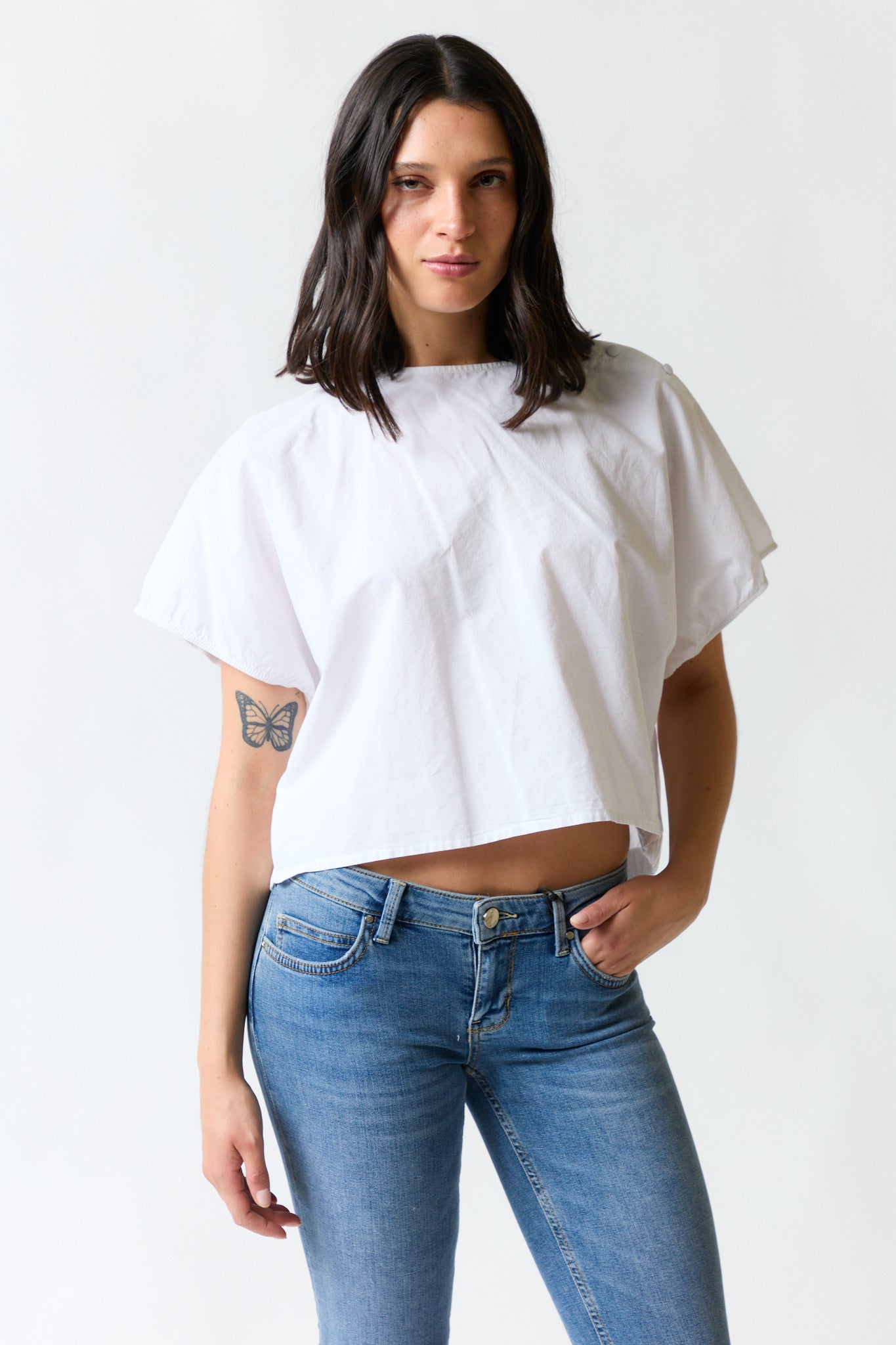 mujer vistiendo polera blanco Zara, estilo urbano en estudio