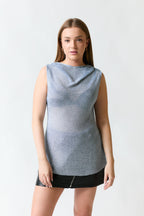 mujer vistiendo polera brillante plateado Zara, estilo urbano en estudio