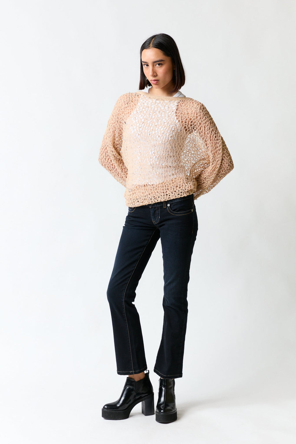 mujer vistiendo polera dorado Zara, estilo urbano en estudio