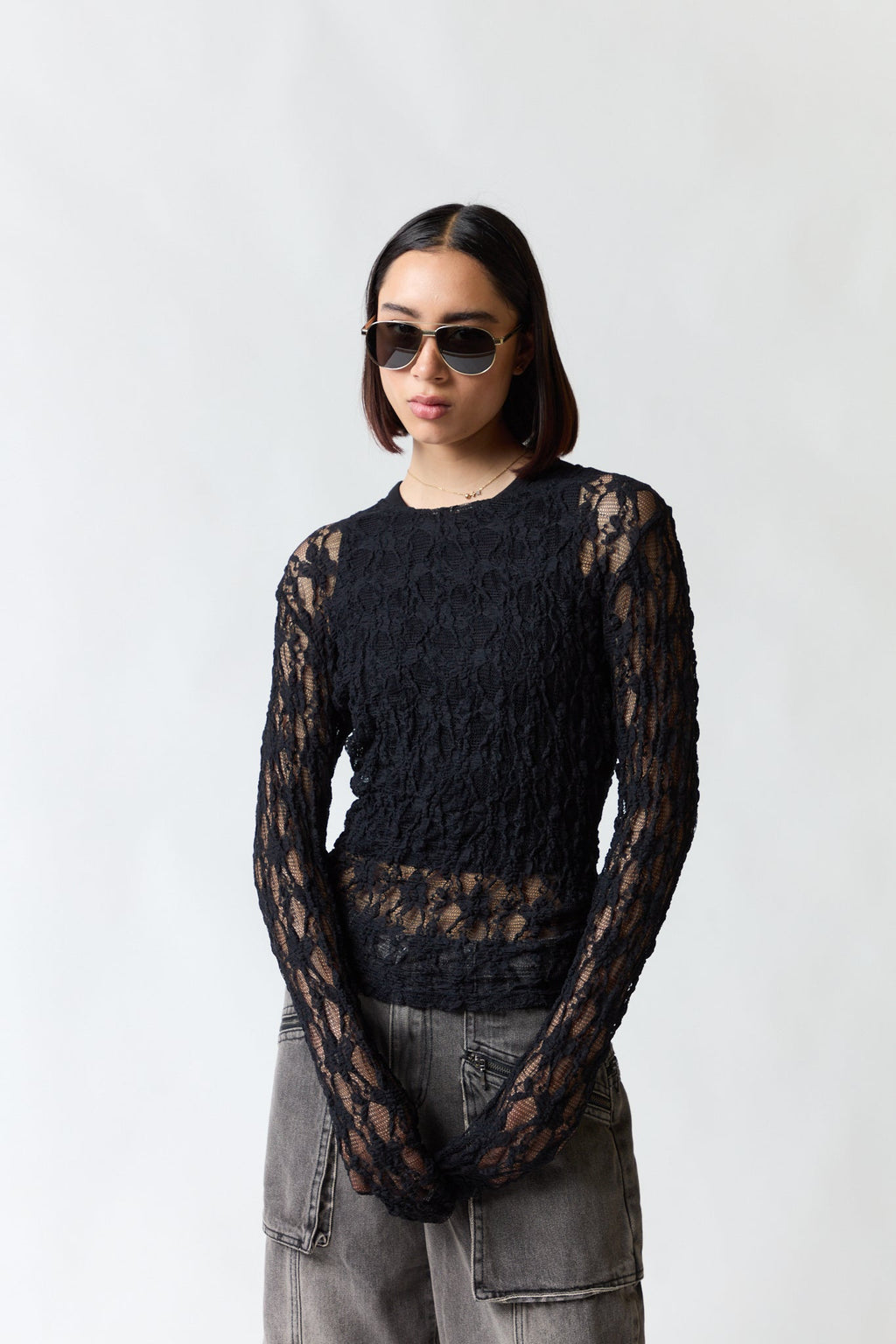 mujer vistiendo polera malla negro Zara, estilo urbano en estudio