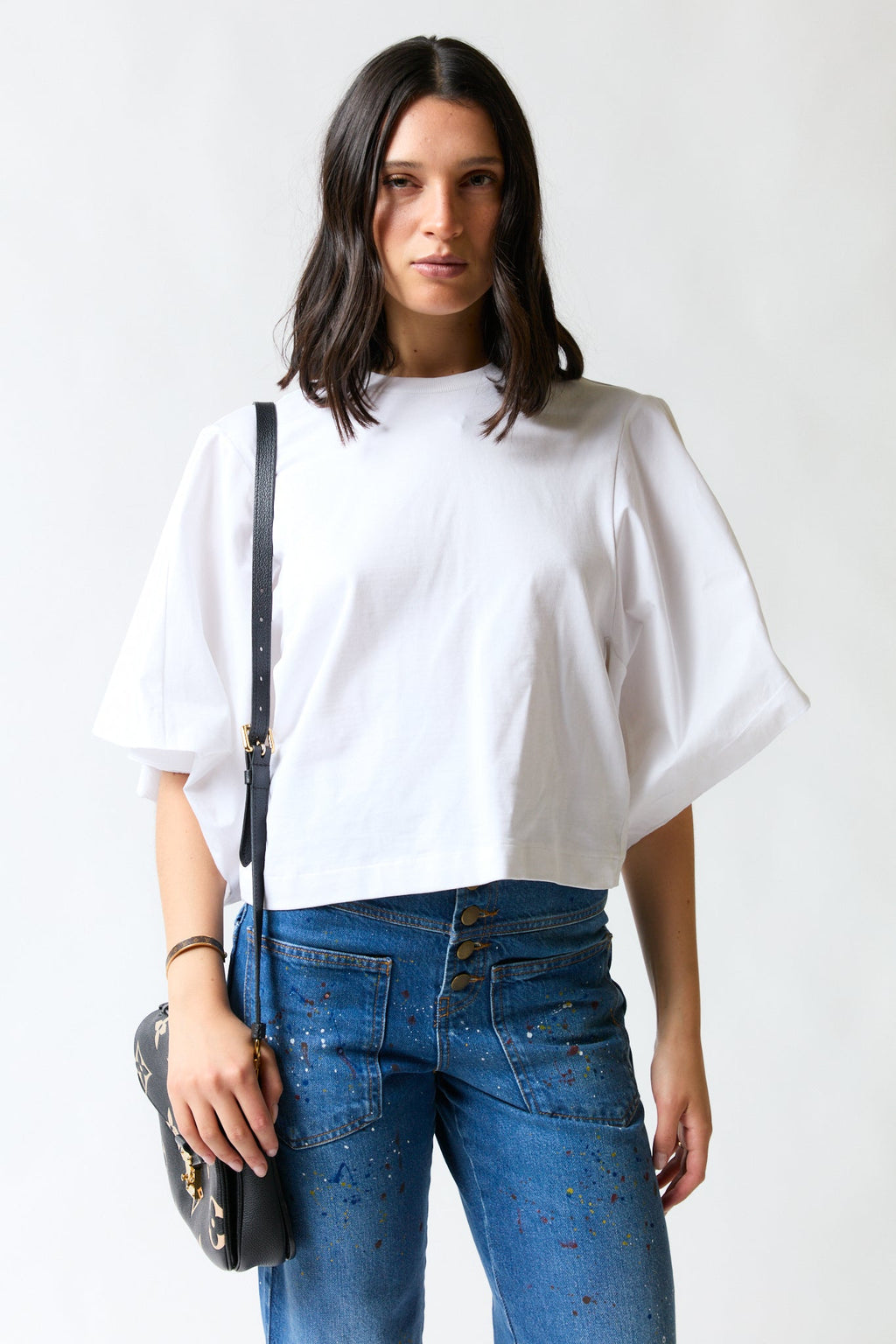 mujer vistiendo polera oversize blanco Zara, estilo urbano en estudio