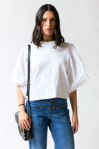 mujer vistiendo polera oversize blanco Zara, estilo urbano en estudio