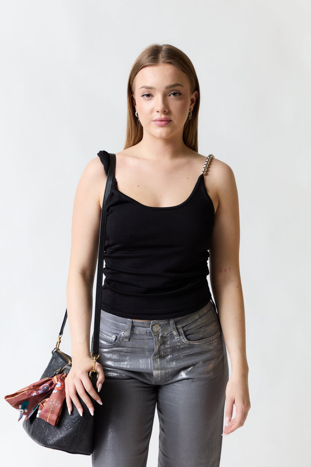 mujer vistiendo polera negro Zara, estilo urbano en estudio