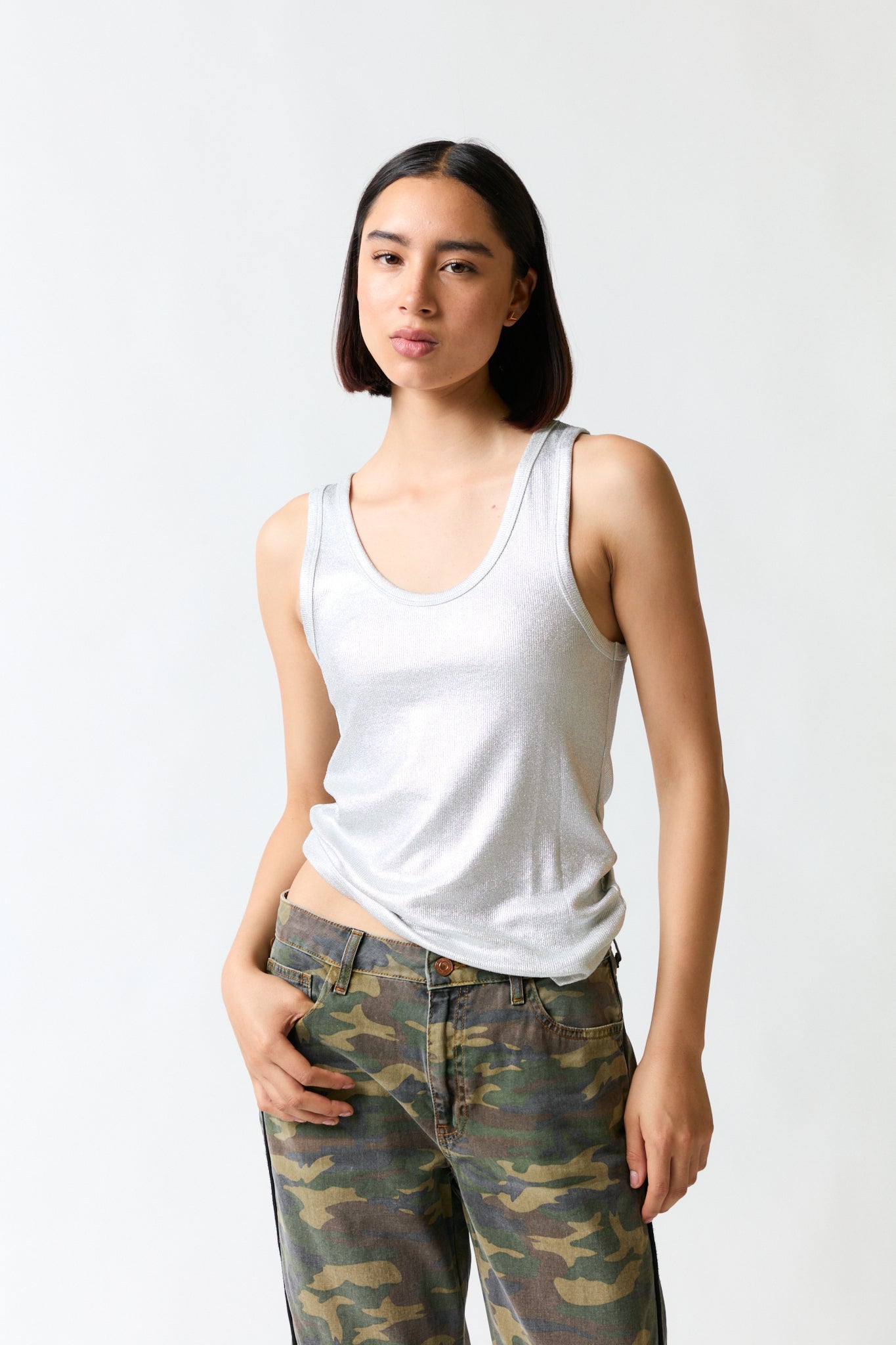 mujer vistiendo polera brillante plateado Zara, estilo urbano en estudio