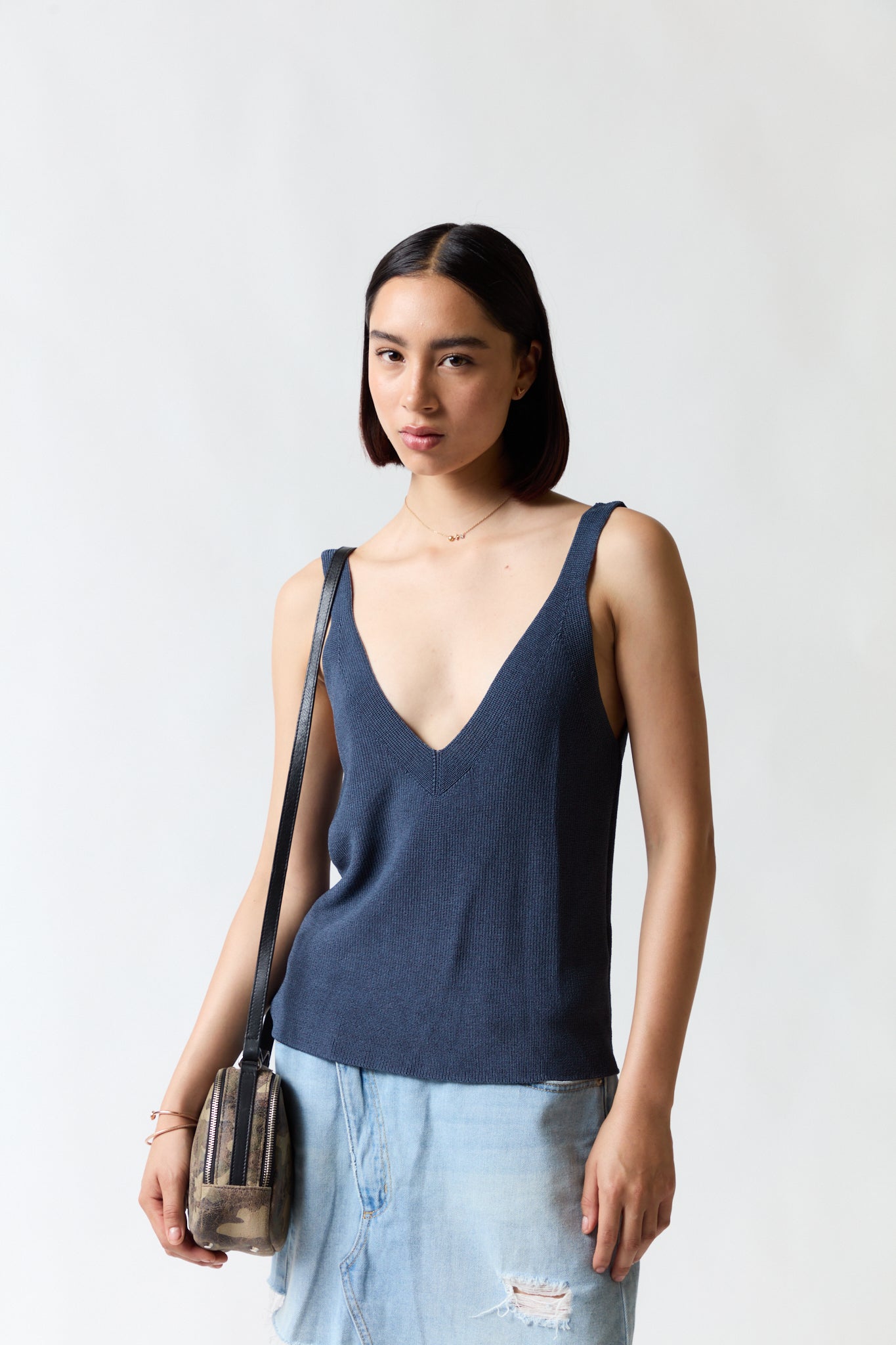 mujer vistiendo polera azul Zara, estilo urbano en estudio