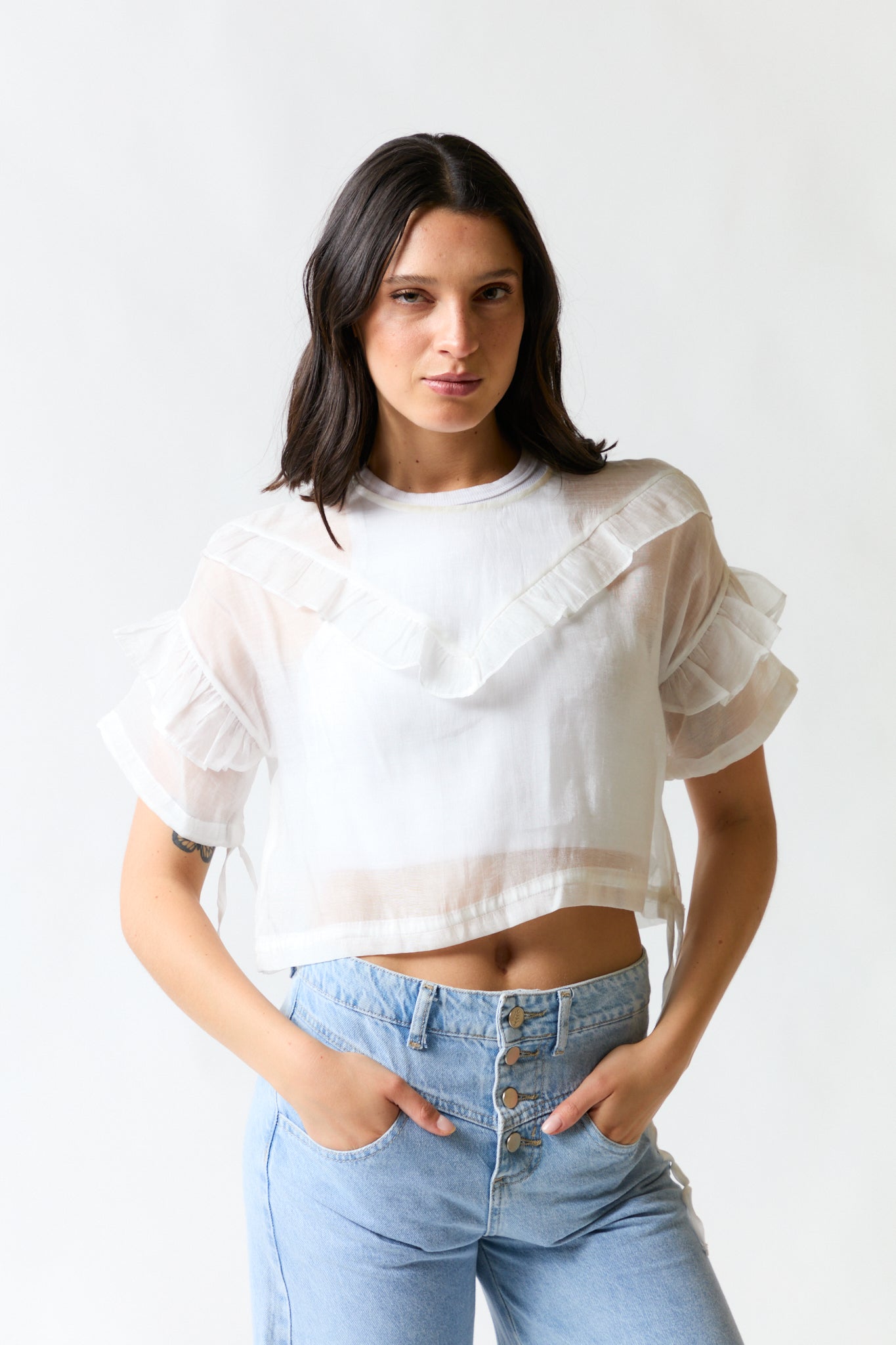 mujer vistiendo polera blanco Stradivarius, estilo urbano en estudio