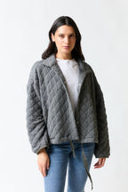 mujer vistiendo chaqueta gris Zara, estilo urbano en estudio