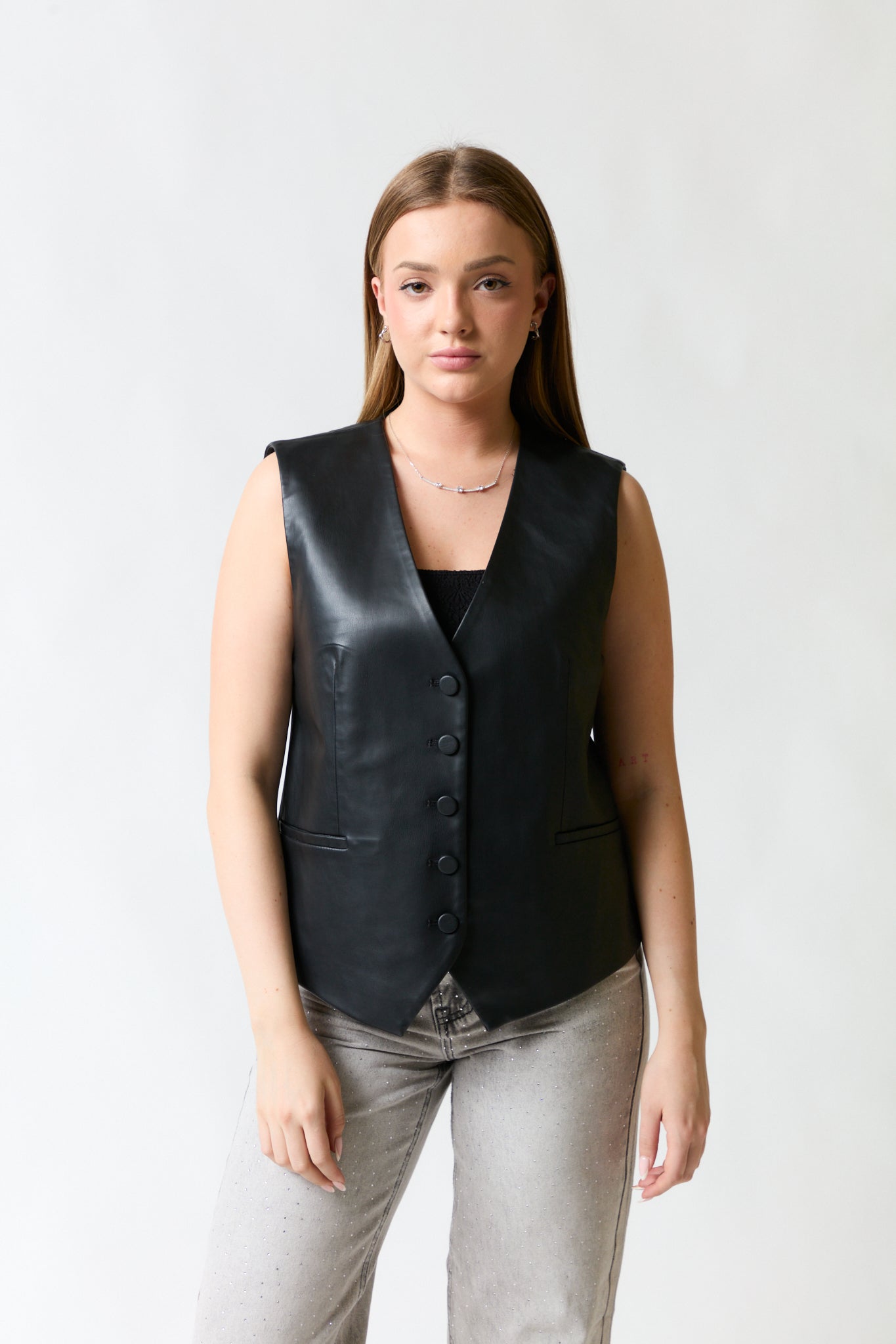 mujer vistiendo chaleco negro Zara, estilo urbano en estudio