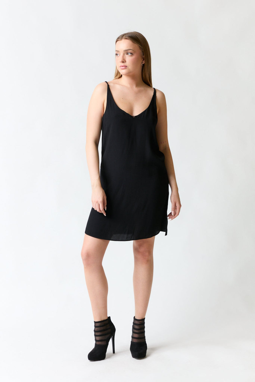 mujer vistiendo vestido negro Zara, estilo urbano en estudio