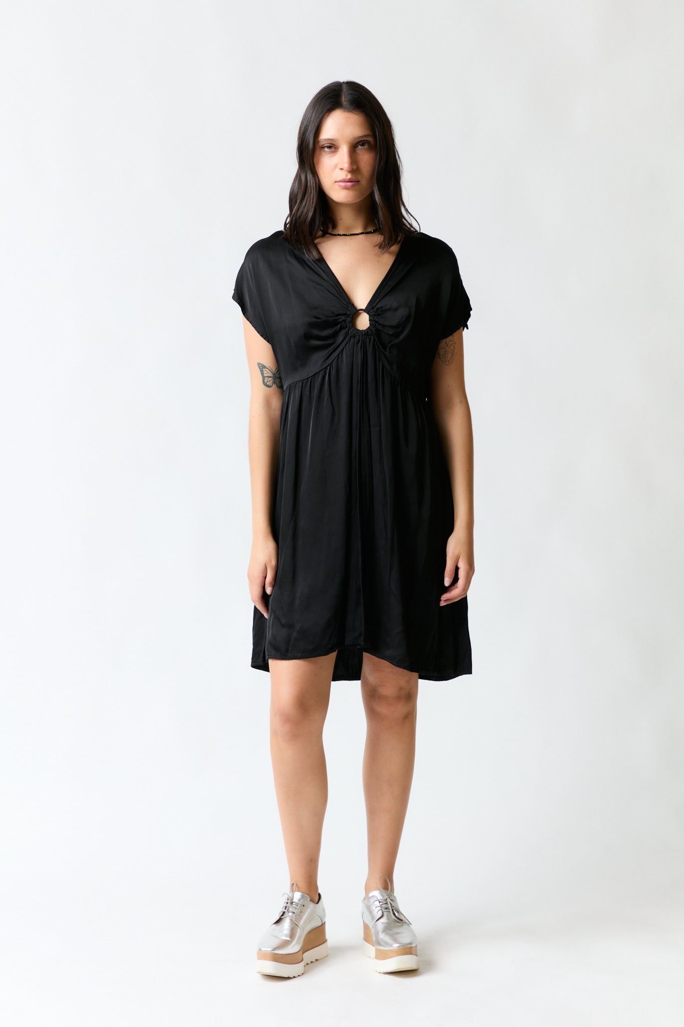 mujer vistiendo vestido negro Zara, estilo urbano en estudio