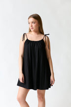 mujer vistiendo vestido negro Mango, estilo urbano en estudio