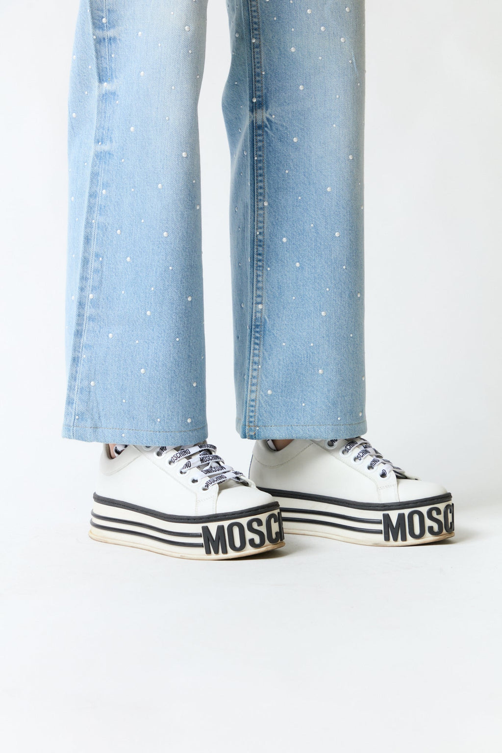 mujer vistiendo producto blanco Moschino, estilo urbano en estudio