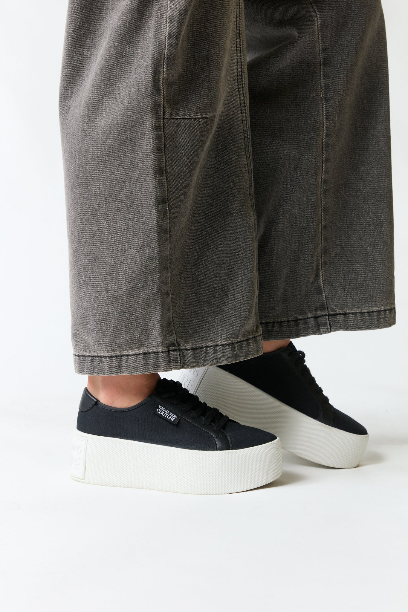 mujer vistiendo producto negro Versace, estilo urbano en estudio