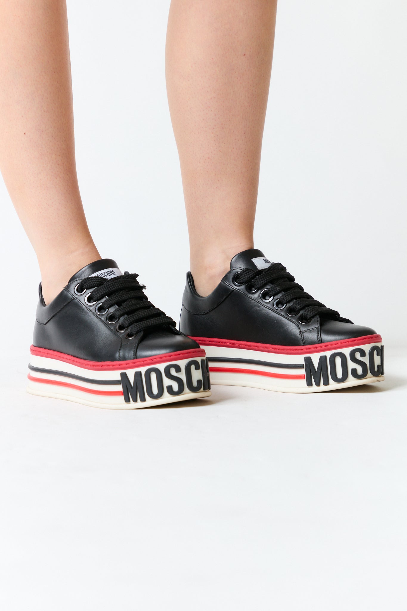 mujer vistiendo producto negro rojo Moschino, estilo urbano en estudio