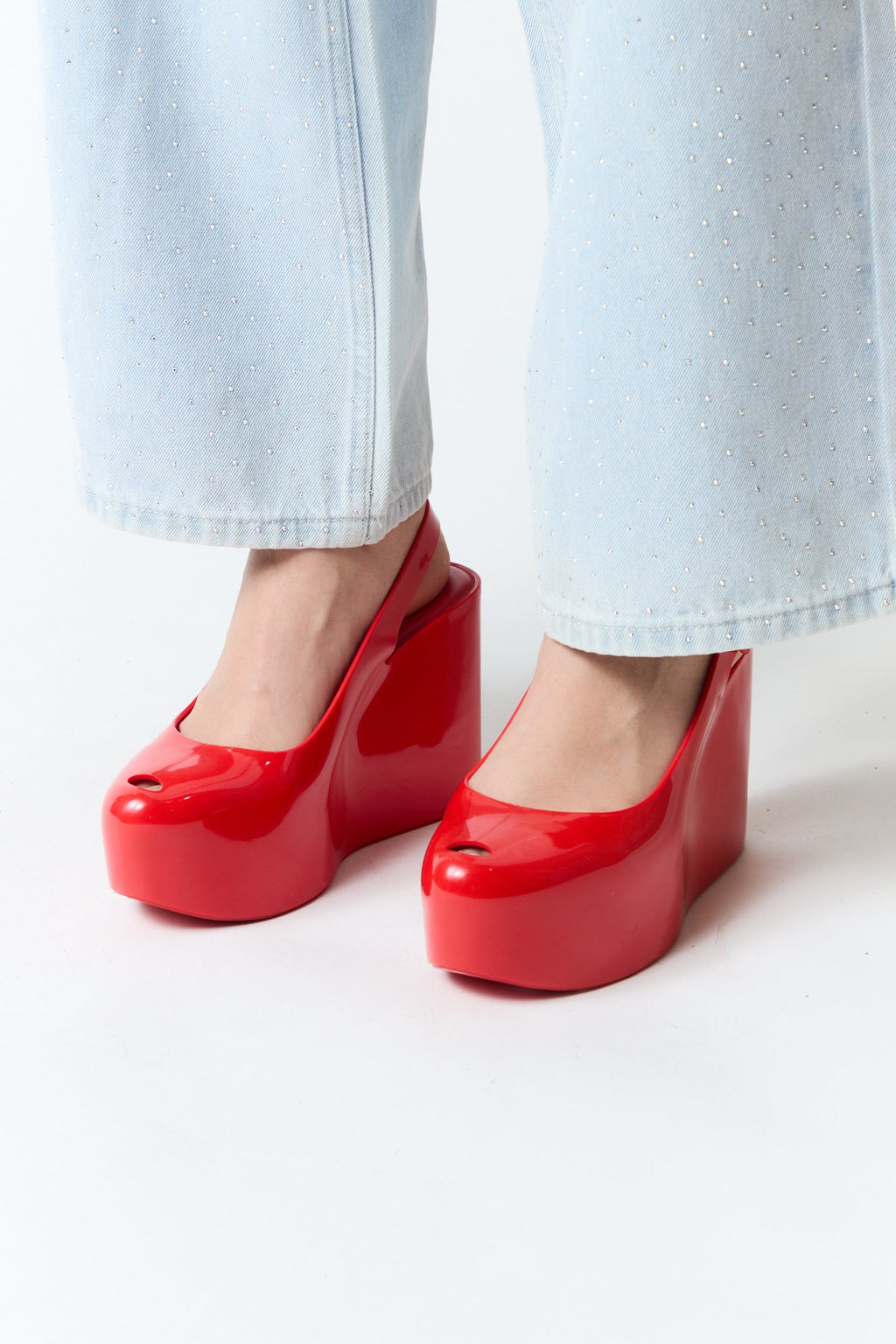 mujer vistiendo producto rojo Melissa, estilo urbano en estudio