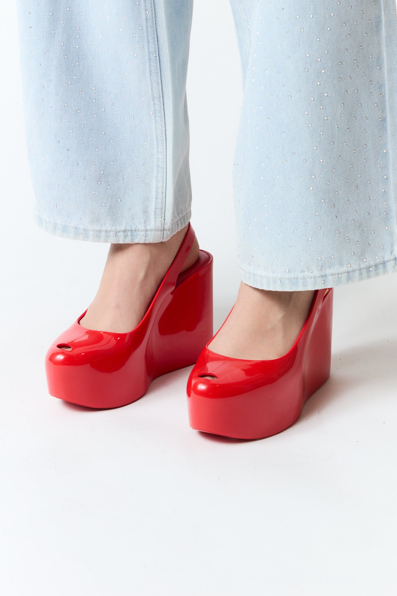 mujer vistiendo producto rojo Melissa, estilo urbano en estudio